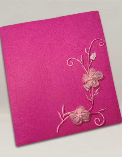 Album foto artigianale rivestito con feltro fucsia e un ramo di fiori di raso rosa
